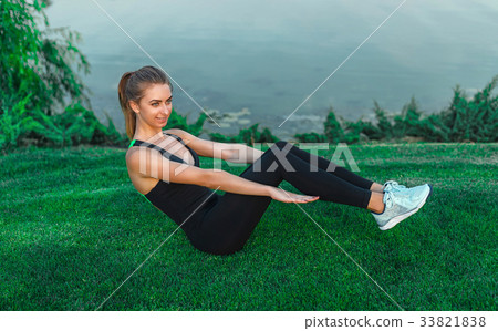Young beautiful woman doing core workout outside 33821838
