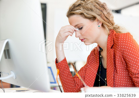 Young woman in office tired 33825639
