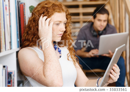 Portrait of two young people sitting at the stairs in office Portrait of two young people sitting at the stairs in office 33833561