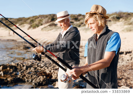Senior man fishing with his grandson 33833869