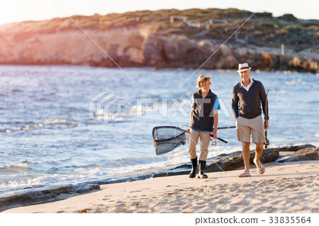 Senior man fishing with his grandson Senior man fishing with his grandson 33835564