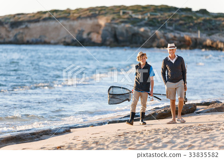 Senior man fishing with his grandson Senior man fishing with his grandson 33835582