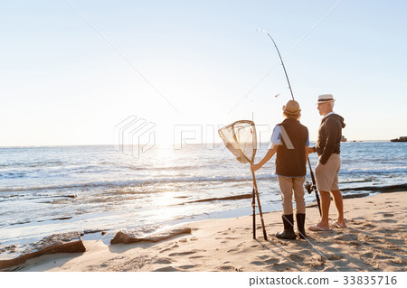 Senior man fishing with his grandson Senior man fishing with his grandson 33835716