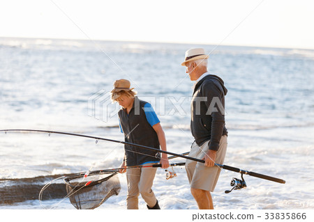 Senior man fishing with his grandson Senior man fishing with his grandson 33835866