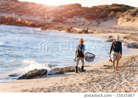 Senior man fishing with his grandson Senior man fishing with his grandson 33835867