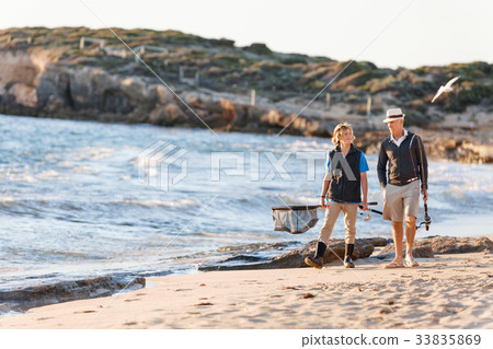 Senior man fishing with his grandson Senior man fishing with his grandson 33835869