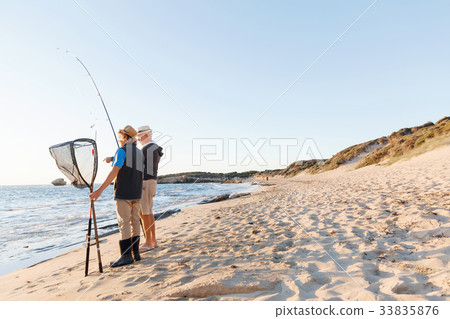 Senior man fishing with his grandson Senior man fishing with his grandson 33835876