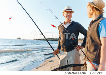 Senior man fishing with his grandson 33835995