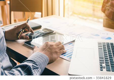 Asian businessman pressing button on calculator Asian businessman pressing button on calculator 33841829