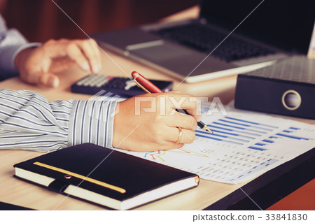 Businessman hand pointing to graph summary report 33841830