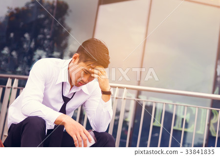 Worried businessman sitting in front of company Worried businessman sitting in front of company 33841835