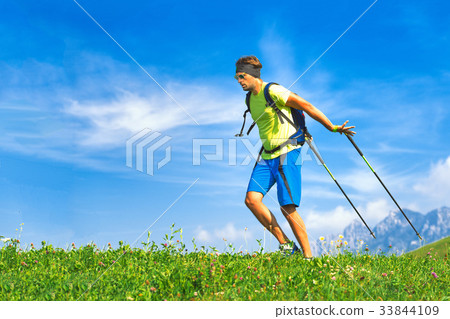 Young man practicing nordic walking in nature 33844109