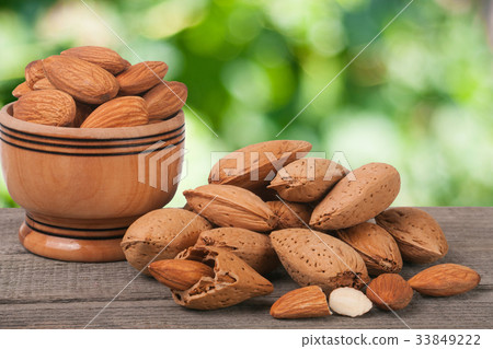 almonds in a bowl on the old wooden board with 33849222