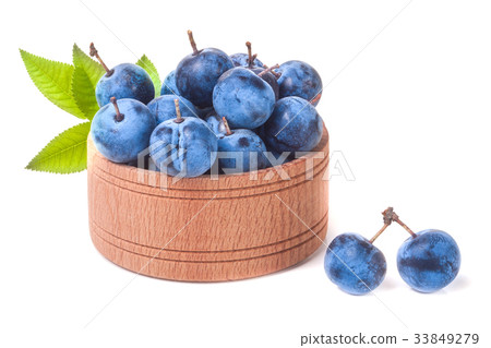 blackthorn berries with leaves in a wooden bowl 33849279