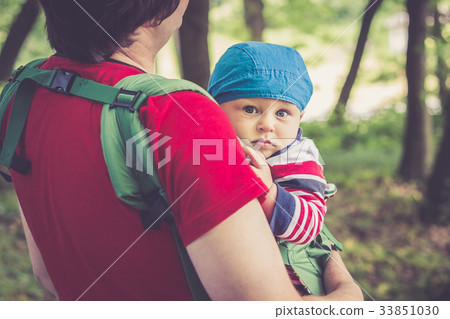 Father holding his son in baby carrier Father holding his son in baby carrier 33851030