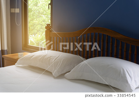White pillows and bedding in blue bedroom interior White pillows and bedding in blue bedroom interior 33854545