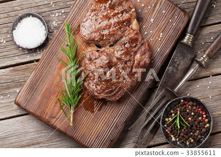 Grilled beef steak with spices on cutting board Grilled beef steak with spices on cutting board 33855611