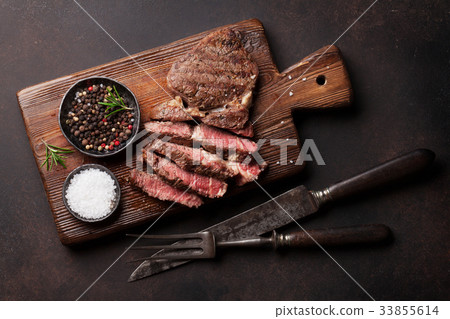 Grilled beef steak with spices on cutting board Grilled beef steak with spices on cutting board 33855614