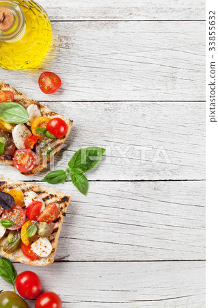 Bruschetta with tomatoes, mozzarella and basil Bruschetta with tomatoes, mozzarella and basil 33855632