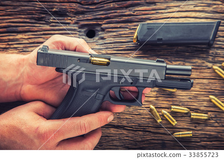 Charging gun. Man hands charging 9mm pistol gun. Charging gun. Man hands charging 9mm pistol gun. 33855723