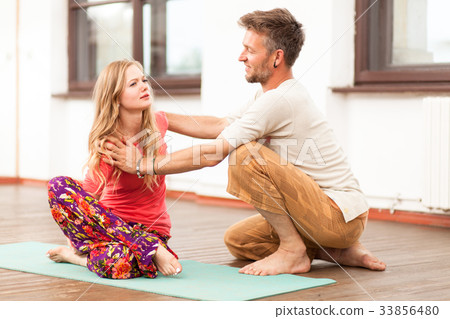 Yoga instructor teaching a woman 33856480