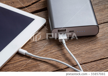 Smartphone charging with power bank. Smartphone charging with power bank. 33857081