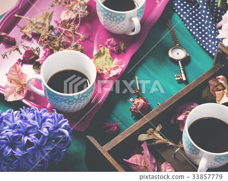 Coffee and flowers on dark background Coffee and flowers on dark background 33857779