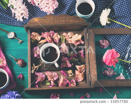 Coffee and flowers on dark background Coffee and flowers on dark background 33857780