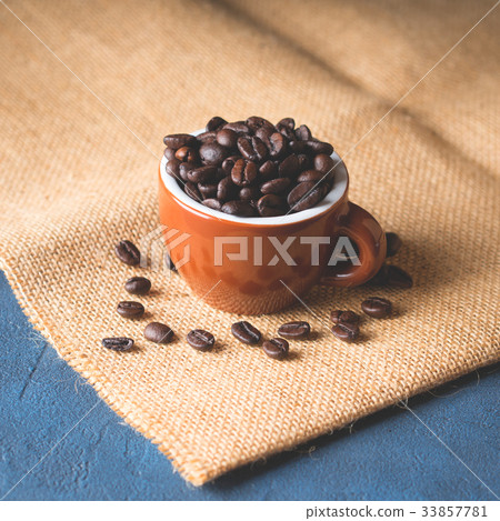 Coffee beans in espresso cup on burlap Coffee beans in espresso cup on burlap 33857781