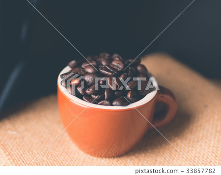 Coffee beans in espresso cup on burlap Coffee beans in espresso cup on burlap 33857782