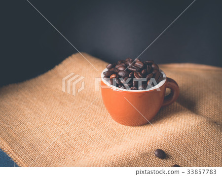 Coffee beans in espresso cup on burlap Coffee beans in espresso cup on burlap 33857783
