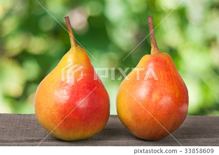 two pears on a dark wooden table with blurred two pears on a dark wooden table with blurred 33858609