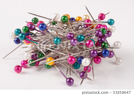 pile of multi-colored sewing pins on a whit pile of multi-colored sewing pins on a whit 33858647