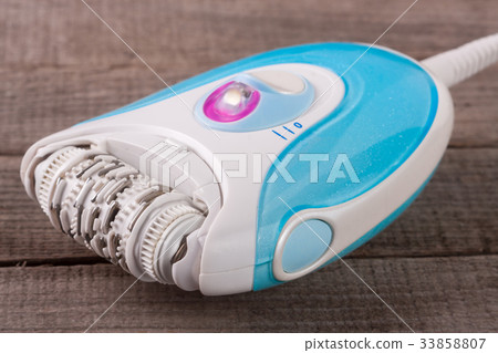electric epilator hair on an old wooden background electric epilator hair on an old wooden background 33858807