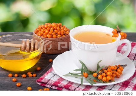 Tea of sea-buckthorn berries with honey on wooden Tea of sea-buckthorn berries with honey on wooden 33858866