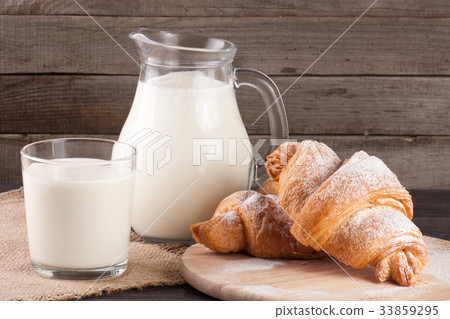 jug and glass of milk with croissants on a wooden jug and glass of milk with croissants on a wooden 33859295