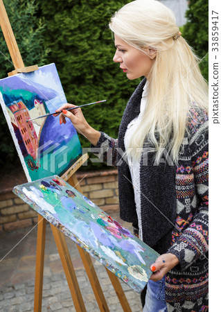 woman artist with a brush in her hand draws on woman artist with a brush in her hand draws on 33859417