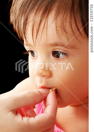 Mother hand feeding her little baby Mother hand feeding her little baby 33859756