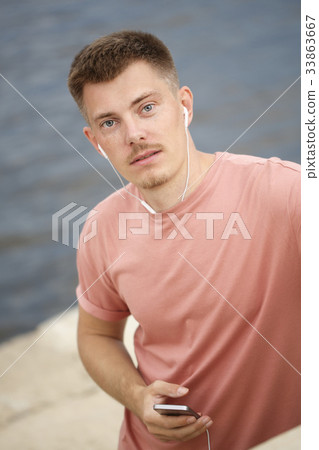 Guy listening to music on headphones Guy listening to music on headphones 33863667