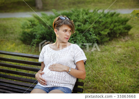 Pregnant girl sitting on bench Pregnant girl sitting on bench 33863668
