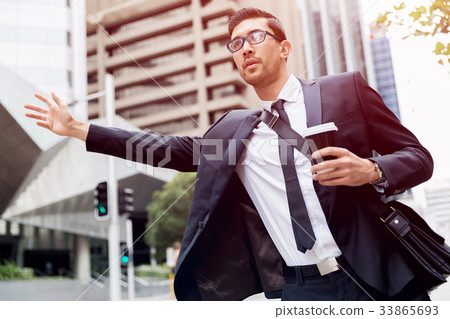 Young businessmen hailing for a taxi 33865693