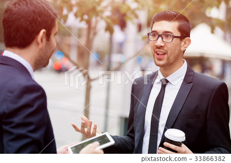 Two businessmen talking outdoors Two businessmen talking outdoors 33866382