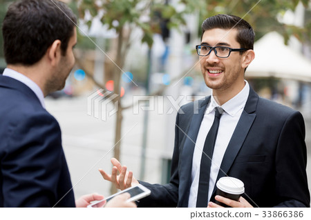 Two businessmen talking outdoors Two businessmen talking outdoors 33866386
