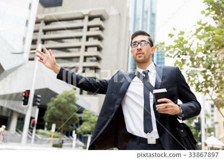 Young businessmen hailing for a taxi 33867897