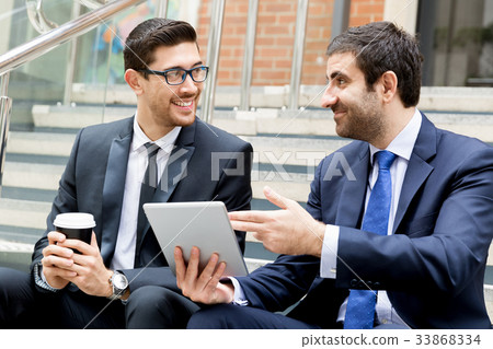 Two businessmen talking outdoors Two businessmen talking outdoors 33868334