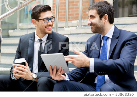 Two businessmen talking outdoors Two businessmen talking outdoors 33868350