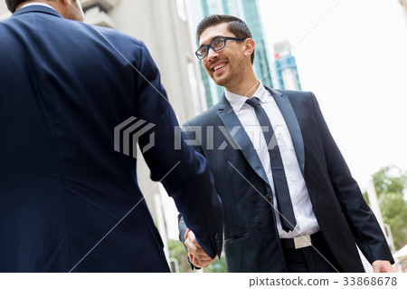 Two businessmen shaking their hands 33868678