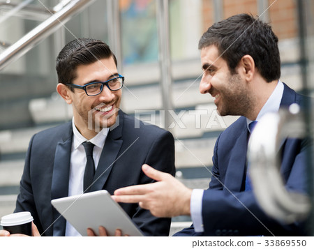 Two businessmen talking outdoors Two businessmen talking outdoors 33869550