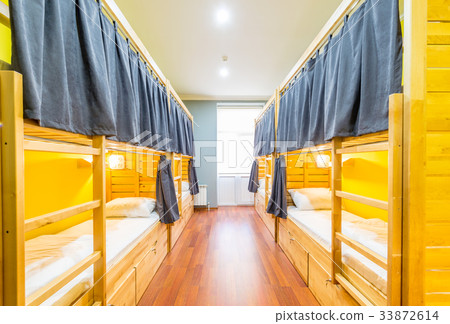 Hostel dormitory beds arranged in room 33872614