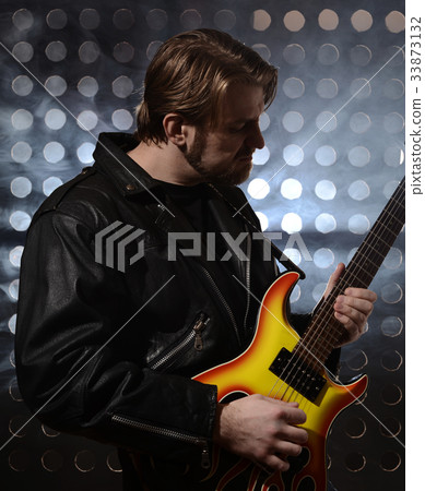 rock guitarist playing electric guitar in fog 33873132